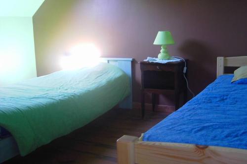 濱海克里耶勒的住宿－Maison Le four à chaux，一间卧室设有两张床和一张桌子上的台灯。