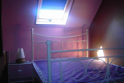 濱海克里耶勒的住宿－Maison Le four à chaux，一间卧室配有一张带窗户的金属床