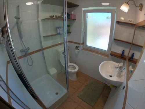 a bathroom with a shower and a toilet and a sink at Pillangó Vendégház in Balatonboglár