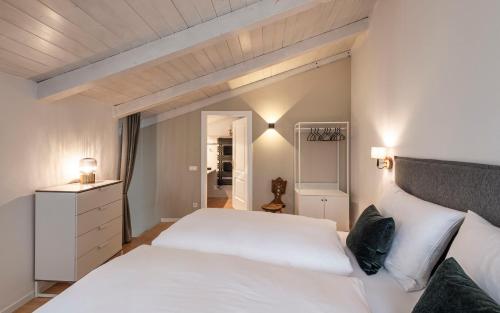 a bedroom with a large white bed with white pillows at Brixen City Maisonette in Bressanone