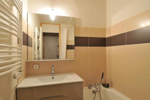 une salle de bains avec lavabo, miroir et baignoire dans l'établissement LA PLAGNE Appartement 2 pièces 30m² à BELLE-PLAGNE, à La Plagne Tarentaise
