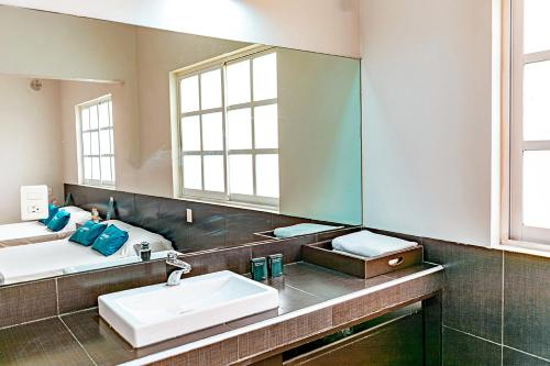 een badkamer met een wastafel en een spiegel bij Ayenda La Selva in Mexico-Stad