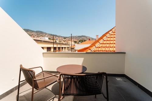 un patio con 2 sillas y una mesa en el balcón en FLH Viola Market Flats with Terrace, en Funchal