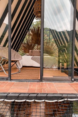 a view of a bedroom through a glass window at Intrepido Glamping in Chinchiná