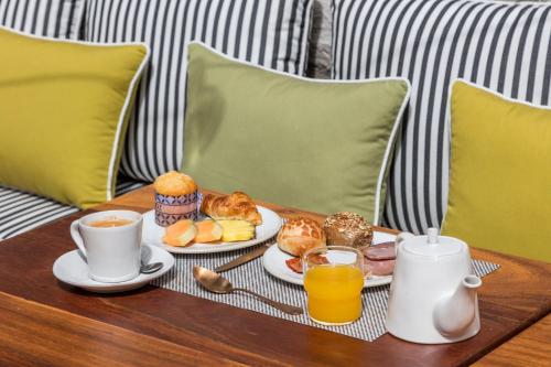 a tray of breakfast foods and drinks on a table at Pur Oporto Boutique Hotel by actahotels in Porto