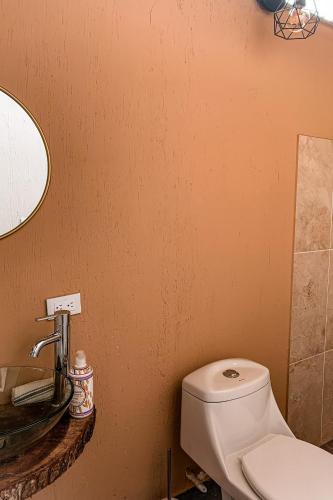 a bathroom with a white toilet and a sink at Intrepido Glamping in Chinchiná