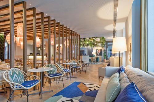 a lobby with a couch and chairs and tables at Pur Oporto Boutique Hotel by actahotels in Porto
