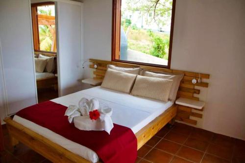 a bedroom with a bed with a red and white bow on it at Maison de charme à Saint-François avec jardin et terrasse in Saint-François
