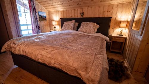 1 dormitorio con 1 cama grande en una habitación con paredes de madera en Izba, en Zinal