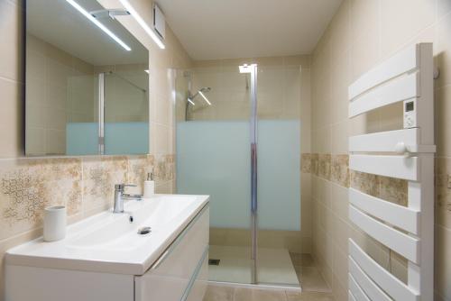 y baño blanco con lavabo y ducha. en Domaine Pedra Llampada Gîtes Montagne, en Villelongue-dels-Monts