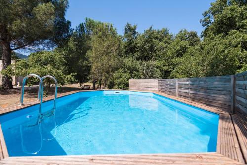 une piscine entourée d'une clôture en bois. dans l'établissement Domaine Pedra Llampada Gîtes Montagne, à Villelongue-dels-Monts