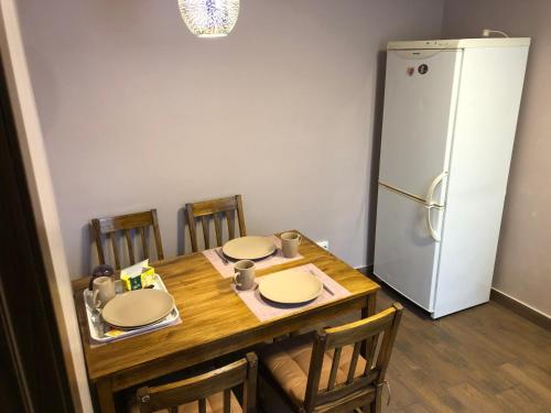 eine Küche mit einem Tisch mit Stühlen und einem Kühlschrank in der Unterkunft Квартира в центре города in Uman
