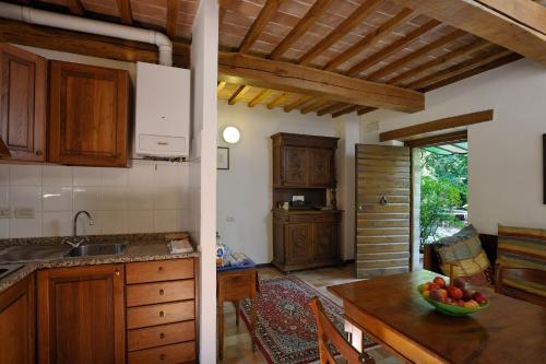 - une cuisine avec une table et un bol de fruits dans l'établissement Le Gorghe di Valmarino, à Corciano