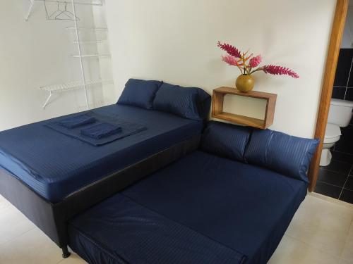 a bed in a room with a plant on top of it at Puerta Azúl Capurganá in Capurganá