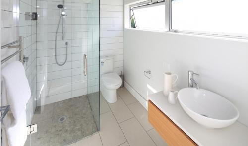 a bathroom with a sink and a shower and a toilet at Tutiri in Oneroa - Stay Waiheke in Oneroa