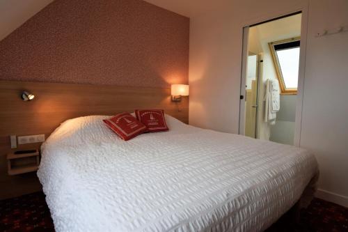 sypialnia z łóżkiem z 2 czerwonymi poduszkami w obiekcie Duplex face à l'Océan-Penhors w mieście Pouldreuzic