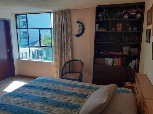 a bedroom with a bed and a window at Casa de Tulia in Quito