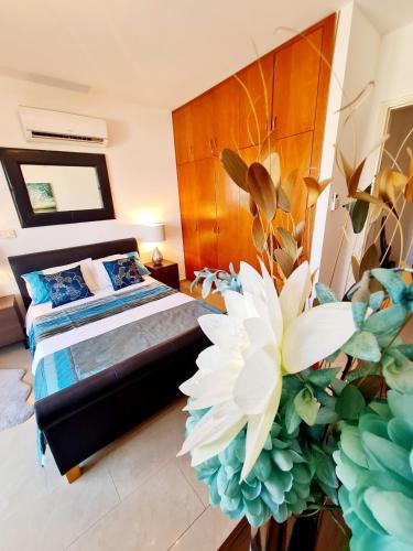 a bedroom with a bed and a large white flower at Stunning apartment C106 with balcony looking over pool in Peyia