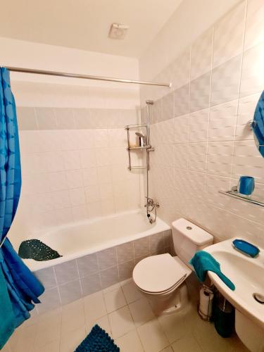 a bathroom with a toilet and a sink and a tub at Stunning apartment C106 with balcony looking over pool in Peyia