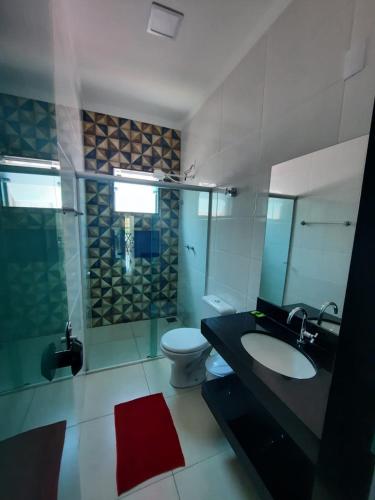 a bathroom with a toilet and a sink and a shower at POUSADA LIMAS SUITES in Capitólio