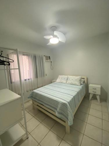 - une chambre blanche avec un lit et une fenêtre dans l'établissement Apartamento no Guarujá a 400 mts da praia, à Guarujá