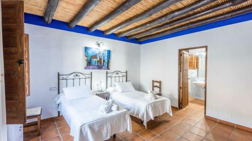 モンダにあるCasa Guajar 2 Monda by Ruralidaysの青い天井の客室で、ベッド2台が備わります。