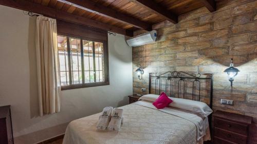 - une chambre dotée d'un lit avec des oreillers roses dans l'établissement Casa Los Valles Alozaina by Ruralidays, à Alozaina