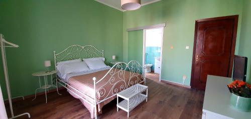 a bedroom with a bed in a room with green walls at La Casa di Andreina in Mondello