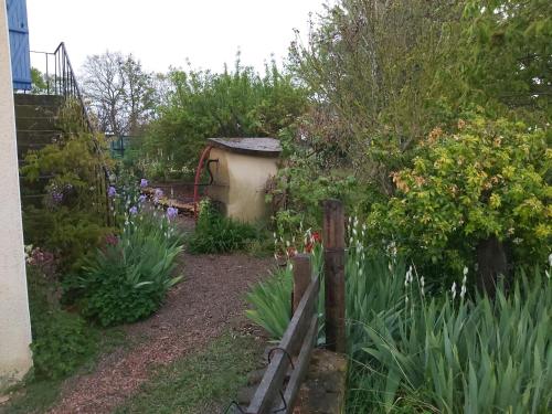a garden with a wooden fence and flowers at Gite du jardin du Bout du Ciel in Céron