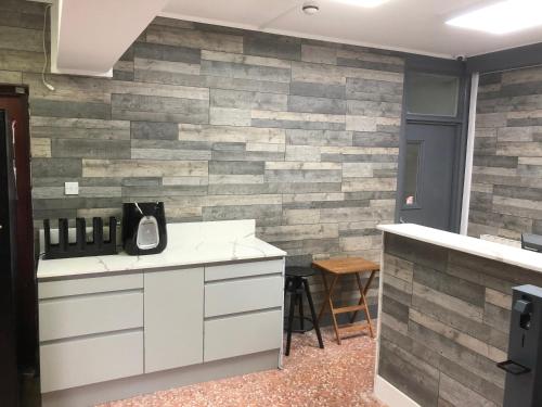 a kitchen with a stone accent wall at Barking Park Hotel in Barking