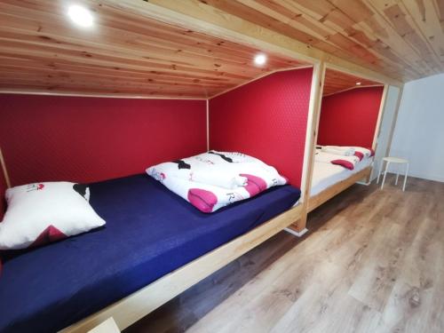 two beds in a room with red walls at Pensjonat Lubianka in Starachowice