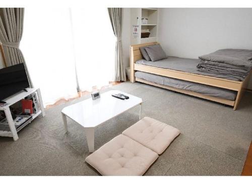a living room with a bed and a coffee table at Marvelous Kokubunji - Vacation STAY 41073v in Kokubunji
