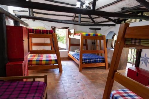 a room with several bunk beds in a house at El Refugio Hostel Curití in Curití