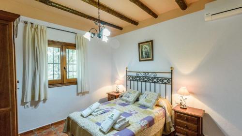 een slaapkamer met een bed, 2 tafels en een raam bij Casa Las Gallinas Orgiva by Ruralidays in Órgiva