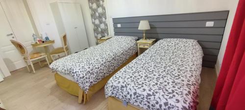 a bedroom with two beds and a table at Strada Maggiore 37 in Bologna