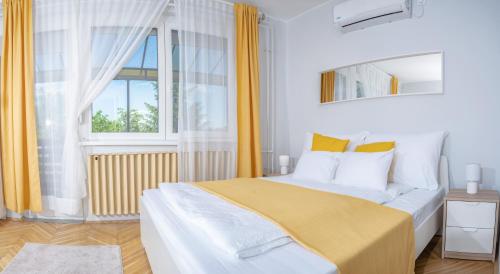 1 dormitorio con 1 cama con cortinas amarillas y ventana en Murányi Vendégház en Mórahalom