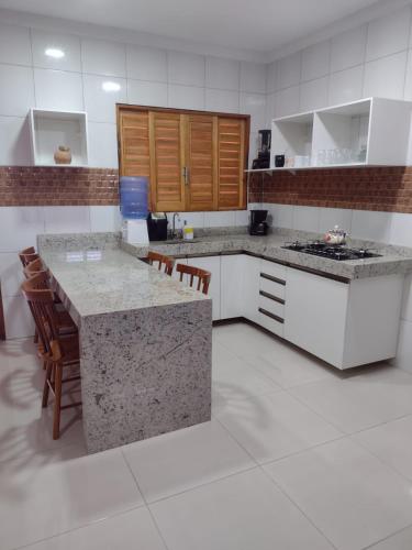 a kitchen with white cabinets and a counter top at Recanto Celestino 3 in São Miguel do Gostoso