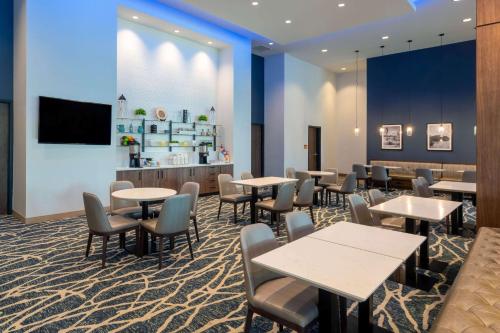 Un comedor con mesas y sillas y un mostrador. en La Quinta Inn & Suites by Wyndham Nashville Downtown Stadium, en Nashville