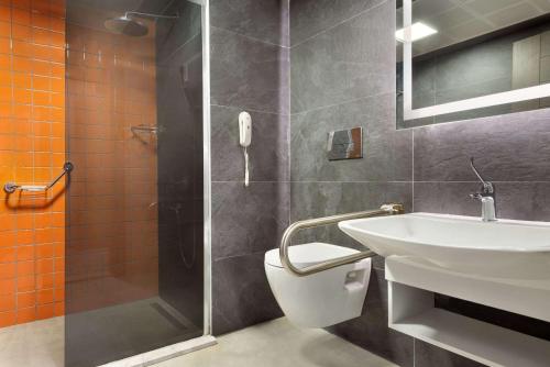 a bathroom with a toilet and a sink and a shower at Days Hotel by Wyndham Ankara Cankaya in Ankara
