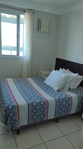 a large bed in a room with a window at D frente Green D 3 in Vila Velha