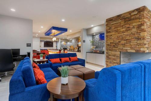 Comfort Inn & Suites في ممفيس: غرفة معيشة مع أرائك زرقاء ومدفأة
