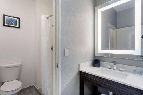 a bathroom with a toilet and a sink and a mirror at Comfort Inn & Suites Memphis East in Memphis