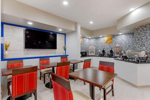 a restaurant with tables and chairs and a counter at Comfort Inn & Suites Memphis East in Memphis