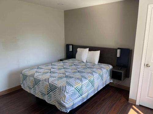 a bedroom with a bed with a comforter on it at Studio 6 Peoria IL in Peoria