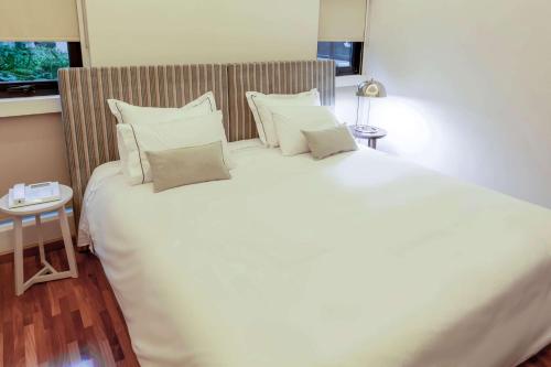 a bedroom with a large white bed with pillows at Esplendor by Wyndham Buenos Aires Tango in Buenos Aires