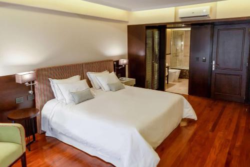 a bedroom with a large white bed and a bathroom at Esplendor by Wyndham Buenos Aires Tango in Buenos Aires