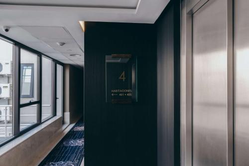 a hallway with a green wall with a sign on it at Esplendor by Wyndham Buenos Aires Tango in Buenos Aires