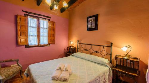 una camera da letto con un letto e un paio di pantofole sopra di Casa Tobalo Hijo Almachar by Ruralidays ad Almáchar