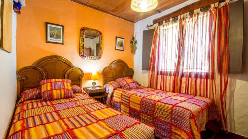 um quarto de hotel com duas camas e um espelho em Casa El Olivarito Jubrique by Ruralidays em Jubrique