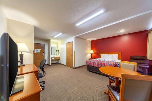 Econo Lodge في Sioux Center: غرفة في الفندق مع سرير ومكتب